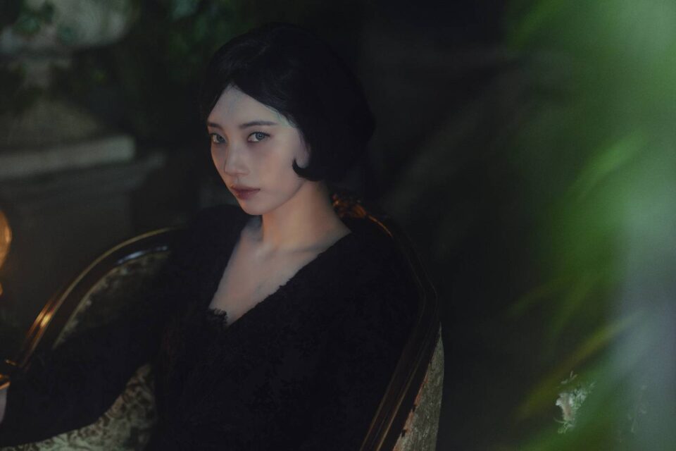 dorama-delusion-mulher-de-vestido-preto-sentada-em-cadeira-antiga-ambiente-escuro