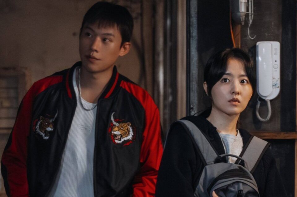 atores-do-dorama-gold-land-em-cena-tensa-em-ambiente-urbano-com-jovem-de-jaqueta-preta-e-vermelha-e-mulher-com-mochila